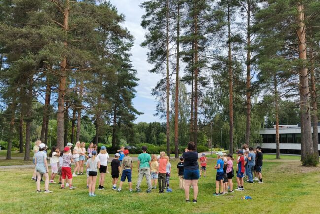 Kesäleiriläiset kaikki yhdessä selkä kameraa päin